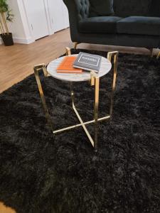 a coffee table with a laptop on top of a rug at Lux One Bedroom Apartment in Barking