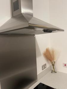 een keuken met een roestvrijstalen fornuis top oven bij Lux One Bedroom Apartment in Barking