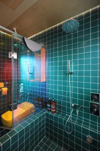 a blue tiled bathroom with a shower and a toilet at Entire apartment or single rooms in Homegarden Park near Camp Humprehys in Pyeongtaek