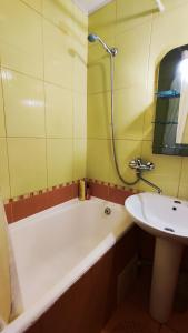 a bathroom with a bath tub and a sink at Василя Стуса 10 City Rooms in Bila Tserkva