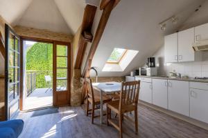 eine Küche und ein Esszimmer mit einem Tisch und Stühlen in der Unterkunft Domaine Les Maurelles in Milhac