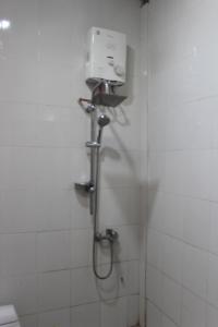 La salle de bains est pourvue d'une douche avec un pommeau de douche. dans l'établissement GRHA PAWITRA TROWULAN, à Trowulan