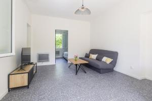 un soggiorno con divano e TV di Terrazza Moriani - Charmant appartement à 500m de la mer a San-Nicolao