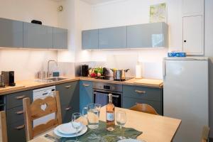 a kitchen with blue cabinets and a table with wine glasses at Chamonix Sud - Balme 402 Duplex - Happy Rentals in Chamonix