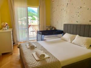 sypialnia z dużym łóżkiem z ręcznikami w obiekcie Apartmani SRNA, Igalo w mieście Igalo