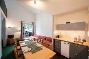 a kitchen with a table and a dining room at Chamonix Sud - Balme 402 Duplex - Happy Rentals in Chamonix