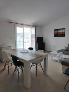 sala de estar con mesa blanca y sillas en Apartments Radić, en Rogoznica