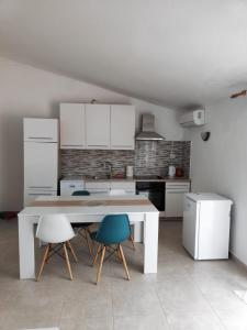 a kitchen with a table and chairs in a room at Apartments Radić in Rogoznica