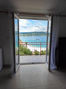 a room with a large window with a view of the water at Apartments Radić in Rogoznica