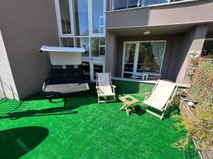 - une cour avec 2 chaises longues et un barbecue dans l'établissement Apartment for rent in Sunny Beach/ Nessebar, à Nessebar