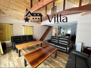a waiting room with leather furniture and a table at Meteor Garden in Hakuba