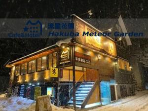 a building in the snow with a sign on it at Meteor Garden in Hakuba +101 photos