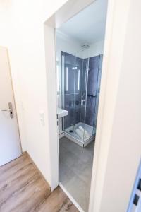 a bathroom with a shower and a mirror at Hökis-Zimmervermietung 1 in Brande-Hörnerkirchen