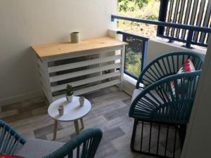 Un balcón con sillas y una mesa y una cómoda. en L'Azur, en Saint-Pierre