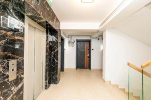 a hallway with a black door and marble walls at Apart HOTEL Fusion Tower in Iaşi
