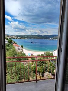 vistas a una playa con un barco en el agua en Apartments Radić, en Rogoznica