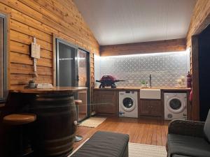 a kitchen with a stove and a washing machine at Hideaway Haven in Mudgee