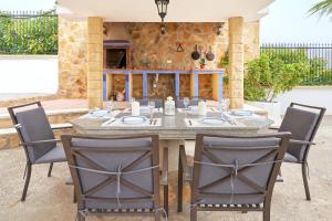a wooden table with chairs in a patio with a tableablish at Villa Soraida in Ítrabo