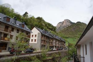 a row of buildings with mountains in the background at Hostal Los Valles in Bielsa