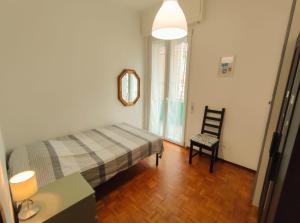 1 dormitorio con cama, silla y espejo en Casa Daria, en Rapallo