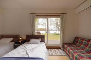 北塩原村的住宿－Lakeside Hotels Kuore，一间卧室设有两张床和窗户。