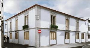 a white building with people standing outside of it at Morgado da Granja in Aveiro