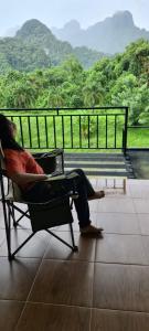 a person sitting in a chair looking out at the mountains at Phu Siab Mhok@KhaoSok in Khao Sok