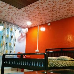 sypialnia z łóżkiem i pomarańczową ścianą w obiekcie KAASH PATHAR DREAM HOUSE w mieście Satara