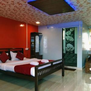a bedroom with a large bed with a red wall at KAASH PATHAR DREAM HOUSE in Satara
