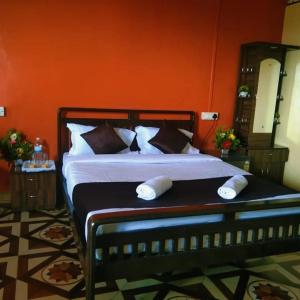 1 dormitorio con 1 cama grande y pared de color naranja en KAASH PATHAR DREAM HOUSE, en Satara