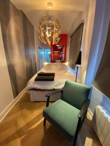 a bedroom with a bed and a chair and a chandelier at Rouen galerie 112 in Rouen +10 photos