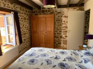 a bedroom with a bed with a blue and white blanket at Chez Milo, rural cottage in Roches