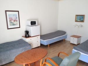 a room with two beds and a table and chairs at Posio Apartments in Posio