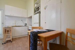 een keuken met een tafel en een keuken met witte kasten bij No no no no in Melbourne
