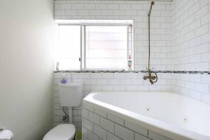baño blanco con bañera y aseo en No no no no, en Melbourne