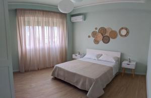 a bedroom with a bed and a large window at Chez Lina - Appartamento Marina in Trapani