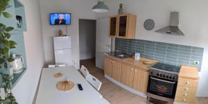 a kitchen with a refrigerator and a table with chairs at Chez Lina - Appartamento Marina in Trapani