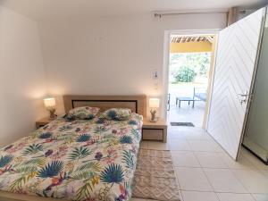 a bedroom with a bed and a door leading to a patio at Villa Syracuse - Chambre privée avec piscine et jardin in Cogolin +18 photos