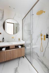 een badkamer met een wastafel en een spiegel bij HIGHSTAY - Luxury Serviced Apartments - Le Marais District in Parijs