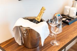 un secchio con una bottiglia di champagne e due bicchieri di vino di Hotel del Conte a Laveno