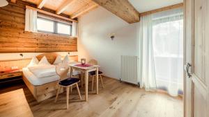 a bedroom with a bed and a table and a window at Pension Walchauhof in Flachau