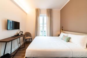 Dormitorio con cama, escritorio y TV en Hotel del Conte en Laveno