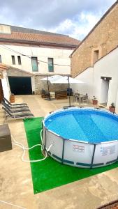 une grande piscine dans une cour avec un bâtiment dans l'établissement Casa Rural El Americano y disfruta de lo natural, à Albentosa