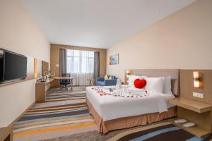 une chambre d'hôtel avec un lit avec un cœur dans l'établissement Vyluk Hotel Guangzhou Baiyun International Airport, à Canton