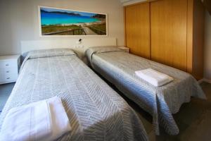 Dos camas en una habitación de hotel con toallas. en Calvario 4, en Vigo