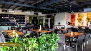 a restaurant with wooden tables and chairs and plants at Savana Hotel & Convention Malang in Malang