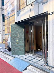 um edifício com um sinal na lateral em Akihabara Nakagawa Inn em Tóquio