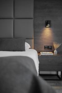 een slaapkamer met een bed en een bijzettafel met een lamp bij Odysseia Hotel Kapetanios in Limassol