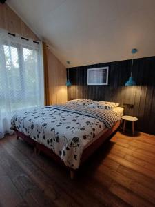 a bedroom with a bed with a comforter on it at Apartamenty być morze in Krynica Morska