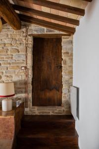 an old wooden door in a brick wall with a lamp at Casa Minotti Relais in Gubbio